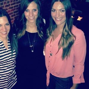 Salmon/Pink button down shirt with cuffed sleeves and tie in front.